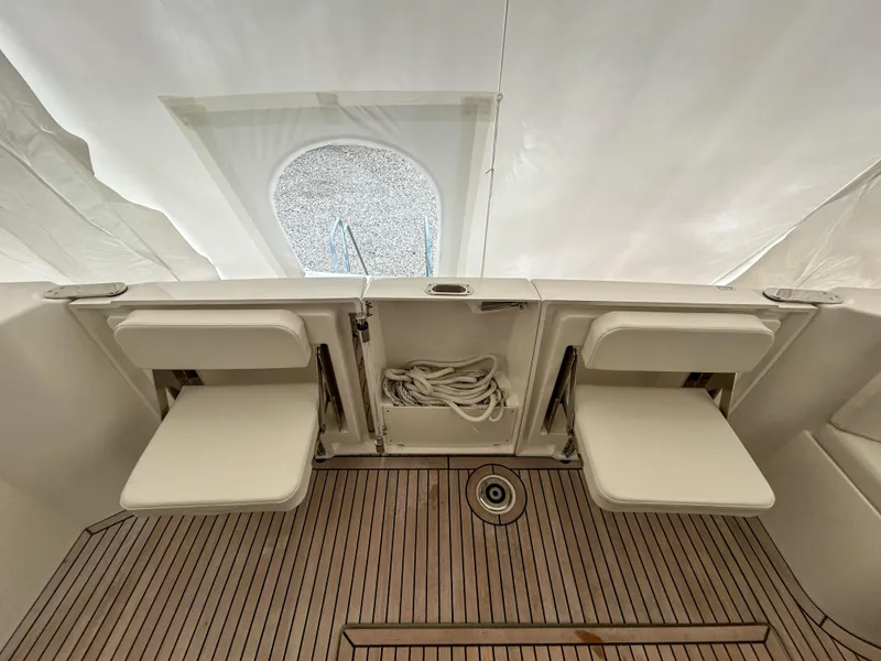 Slide: The Image of 2023 Beneteau Swift Trawler 35 interior with foldable seats and wooden flooring. - 6