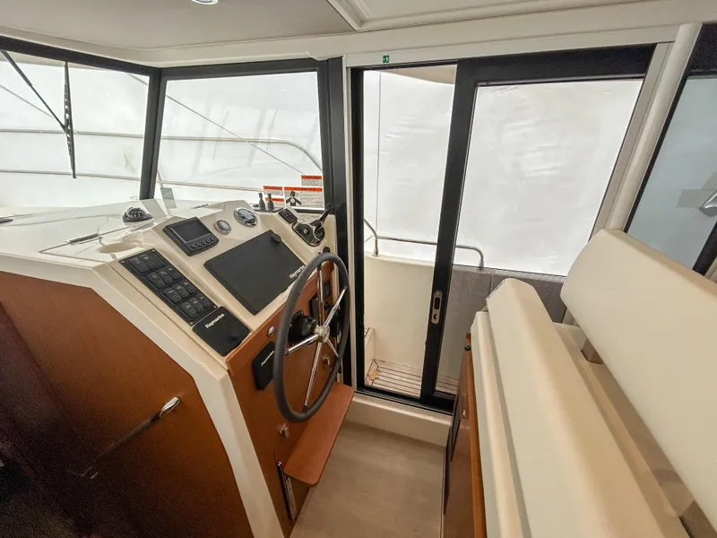 Slide: The Image of 2023 Beneteau Swift Trawler 35 helm station with modern controls and panoramic windows. - 8