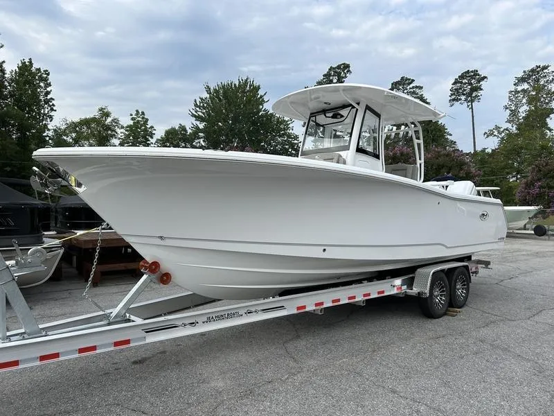 The Image of 2025 Sea Hunt Gamefish 28 boat on trailer, white hull, forward seating, parked outdoors. - 1