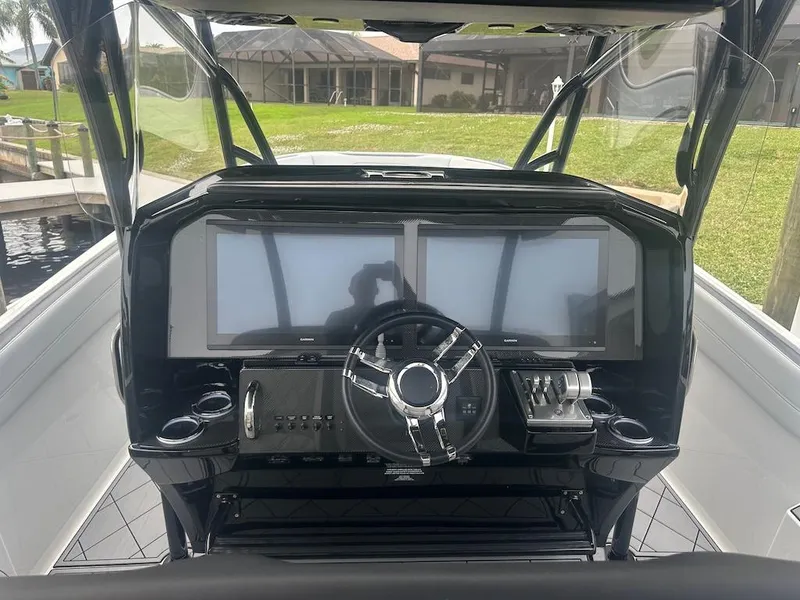 Slide: The Image of 2024 Nor-Tech 340 Sport Center Console helm with dual screens and modern controls. - 13