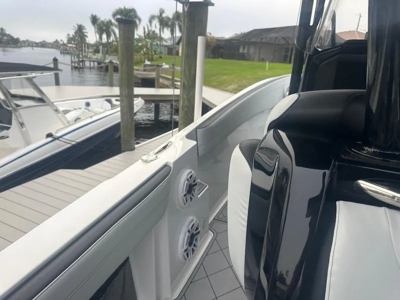 Slide: The Image of 2024 Nor-Tech 340 Sport Center Console docked by a waterfront, showcasing sleek design. - 14