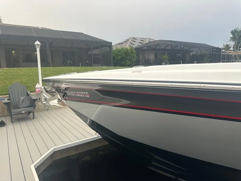 Slide: The Image of 2024 Nor-Tech 340 Sport Center Console boat docked near modern homes. - 27