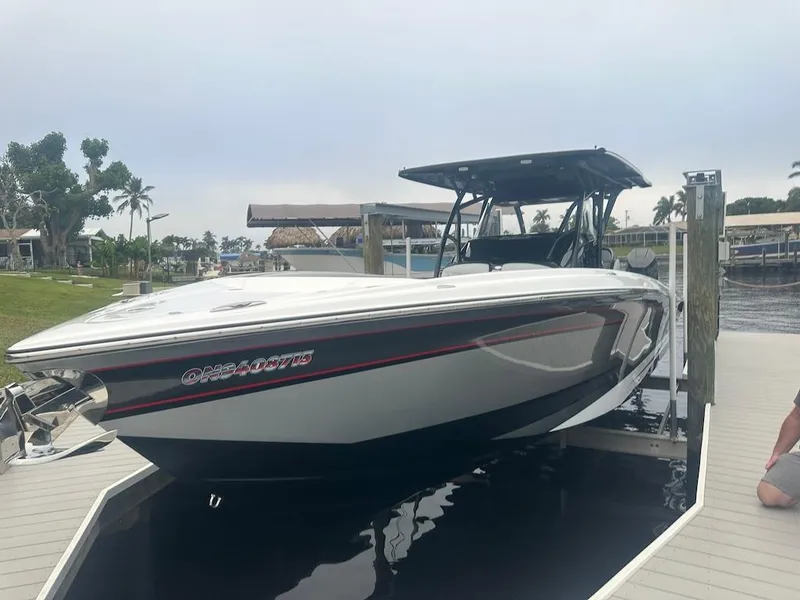 Slide: The Image of 2024 Nor-Tech 340 Sport Center Console boat docked, sleek design, white and black exterior. - 28