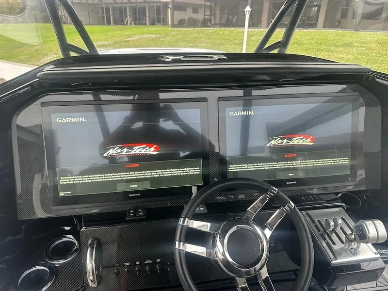 Slide: The Image of 2024 Nor-Tech 340 Sport Center Console dashboard with dual Garmin displays. - 6