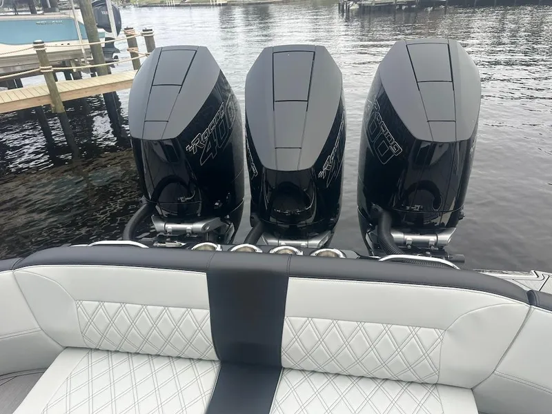 Slide: The Image of 2024 Nor-Tech 340 Sport Center Console with triple outboard engines on a calm dock. - 8