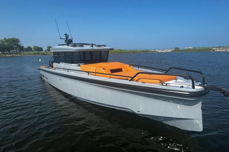 Slide: The Image of 2024 BRABUS Shadow 900 XC Cross Cabin boat on calm water, featuring sleek design and orange accents. - 11