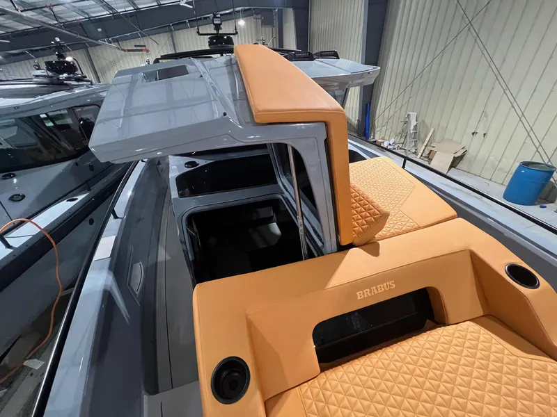 Slide: The Image of 2024 BRABUS Shadow 900 XC Cross Cabin with luxurious tan seating in a showroom. - 12