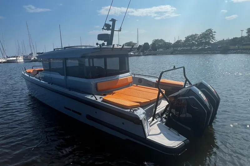 Slide: The Image of 2024 BRABUS Shadow 900 XC Cross Cabin boat with orange seating, docked in a marina. - 7