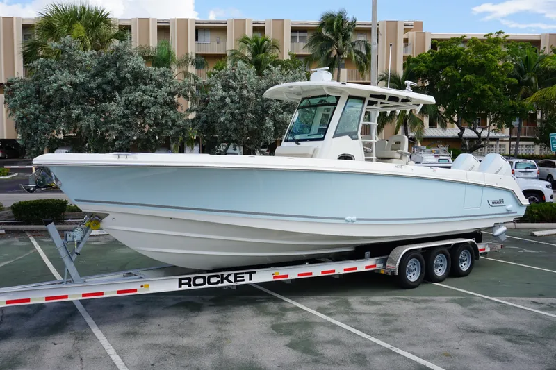 The Image of 2026 Boston Whaler 330 Outrage boat on trailer in parking lot. - 0