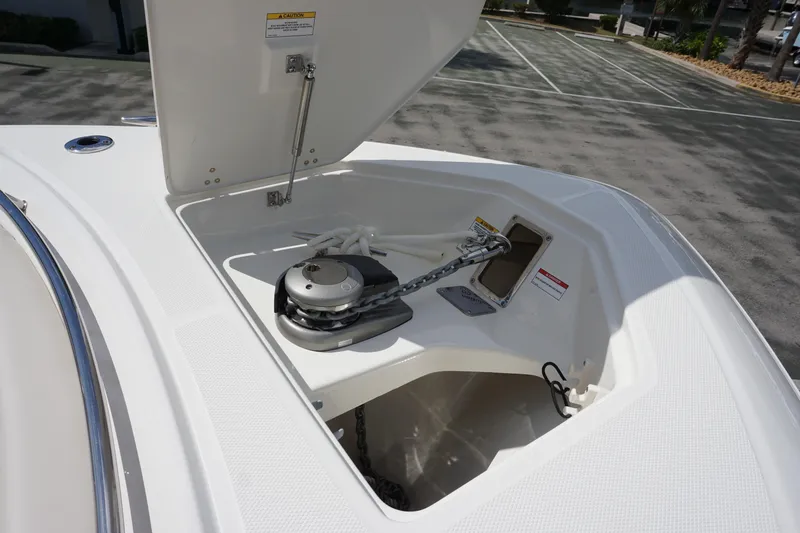 Slide: The Image of 2026 Boston Whaler 330 Outrage anchor compartment with chain and winch. - 24