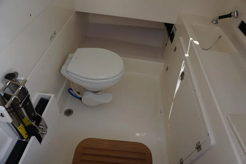 Slide: The Image of 2026 Boston Whaler 330 Outrage boat bathroom with toilet and sink. - 27