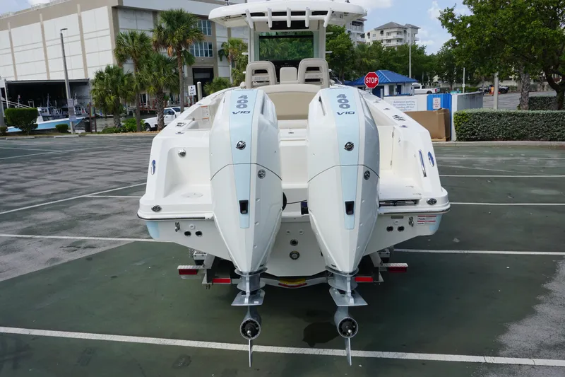 Slide: The Image of 2026 Boston Whaler 330 Outrage with dual 400 V10 engines in a parking lot. - 3