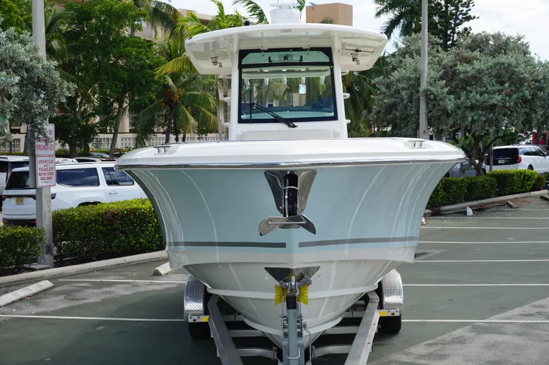 Slide: The Image of 2026 Boston Whaler 330 Outrage boat on trailer in parking lot. - 4