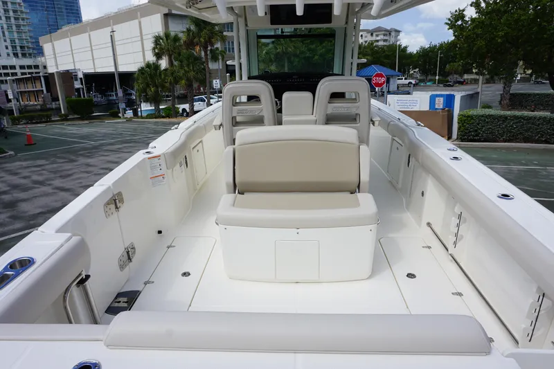 Slide: The Image of 2026 Boston Whaler 330 Outrage boat interior with seating and storage, docked in urban setting. - 5