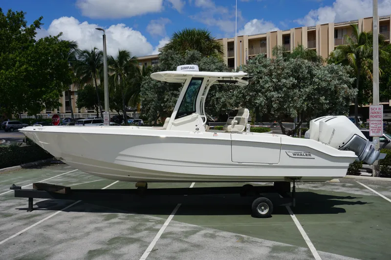 Slide: The Image of 2026 Boston Whaler 280 Dauntless boat on trailer in sunny parking lot. - 1