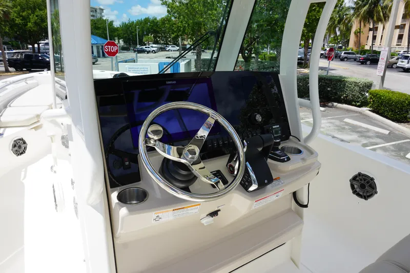 Slide: The Image of 2026 Boston Whaler 280 Dauntless helm with steering wheel and navigation controls. - 19