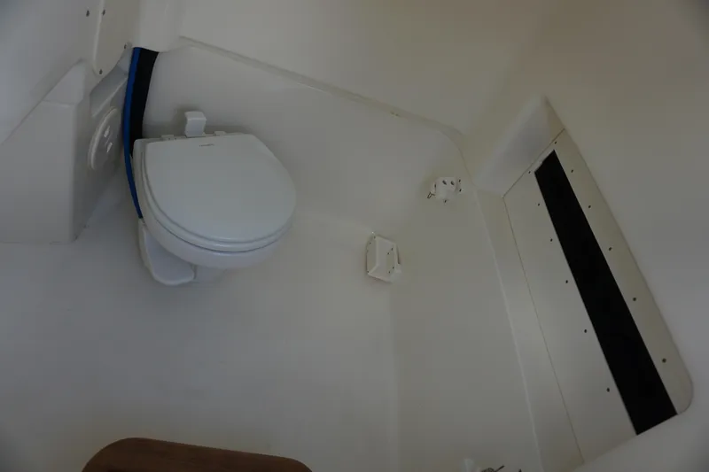 Slide: The Image of Interior of 2026 Boston Whaler 280 Dauntless boat featuring a compact marine toilet. - 43