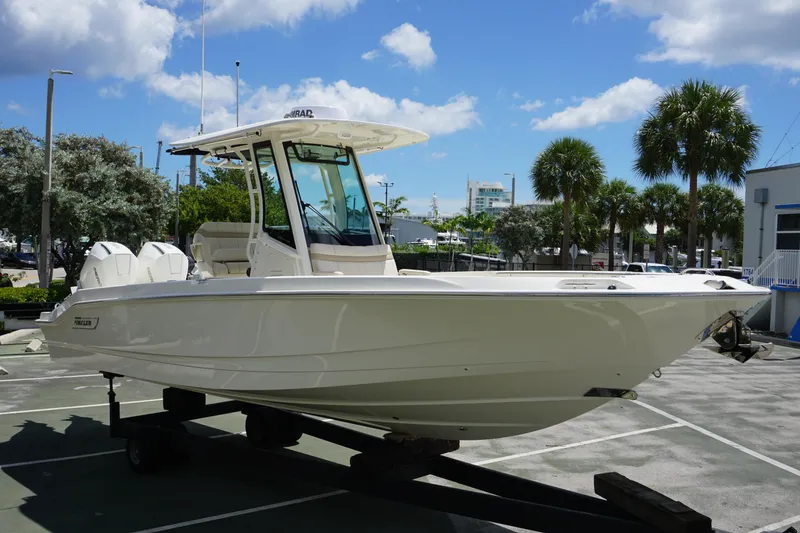 Slide: The Image of 2026 Boston Whaler 280 Dauntless boat on display, sunny day, palm trees in background. - 5