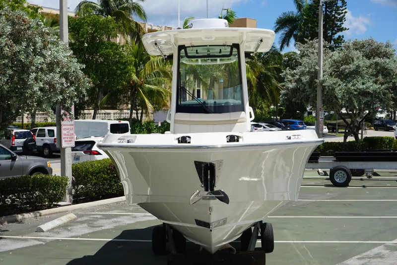 Slide: The Image of 2026 Boston Whaler 280 Dauntless boat parked outdoors, surrounded by trees and vehicles. - 6