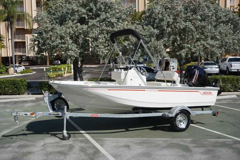 The Image of 2025 Boston Whaler 150 Montauk boat on trailer in parking lot. - 0
