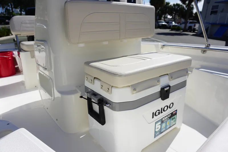 Slide: The Image of 2025 Boston Whaler 150 Montauk boat interior with Igloo cooler and cushioned seating. - 11