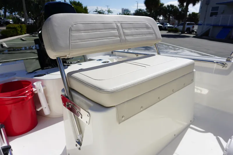 Slide: The Image of 2025 Boston Whaler 150 Montauk boat seat with white upholstery and stainless steel frame. - 13