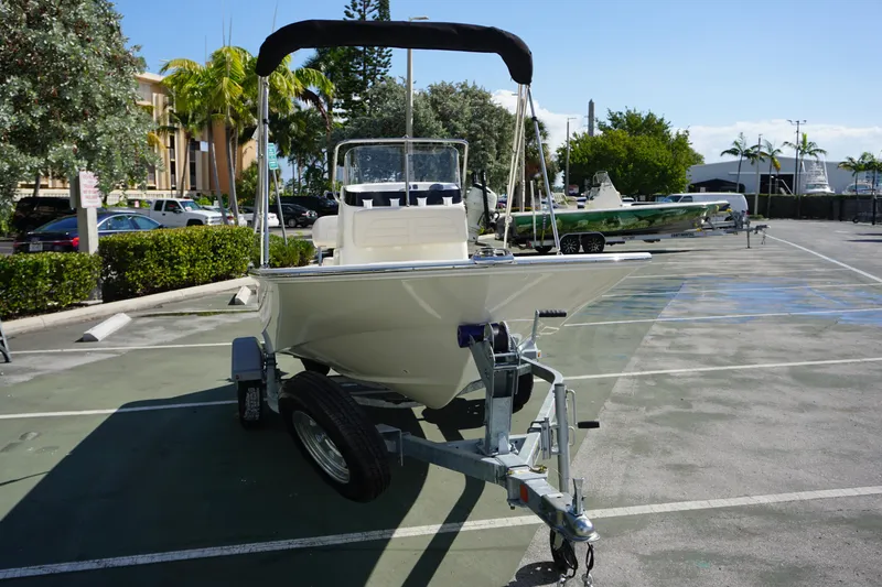 Slide: The Image of 2025 Boston Whaler 150 Montauk boat on trailer in sunny parking lot. - 7