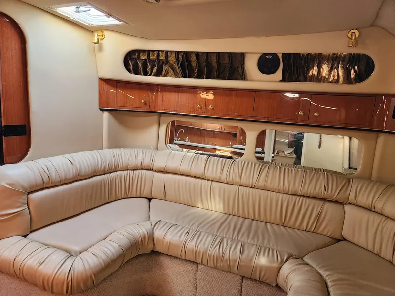 Slide: The Image of Luxurious interior of 2000 Sea Ray 370 Express Cruiser with plush seating and wood cabinets. - 12