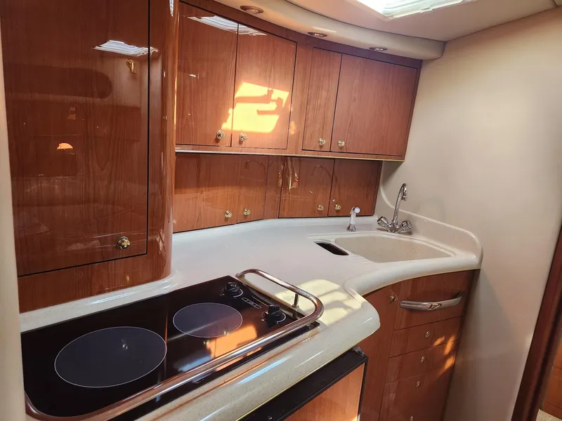 Slide: The Image of 2000 Sea Ray 370 Express Cruiser kitchen with wood cabinets and modern appliances. - 13