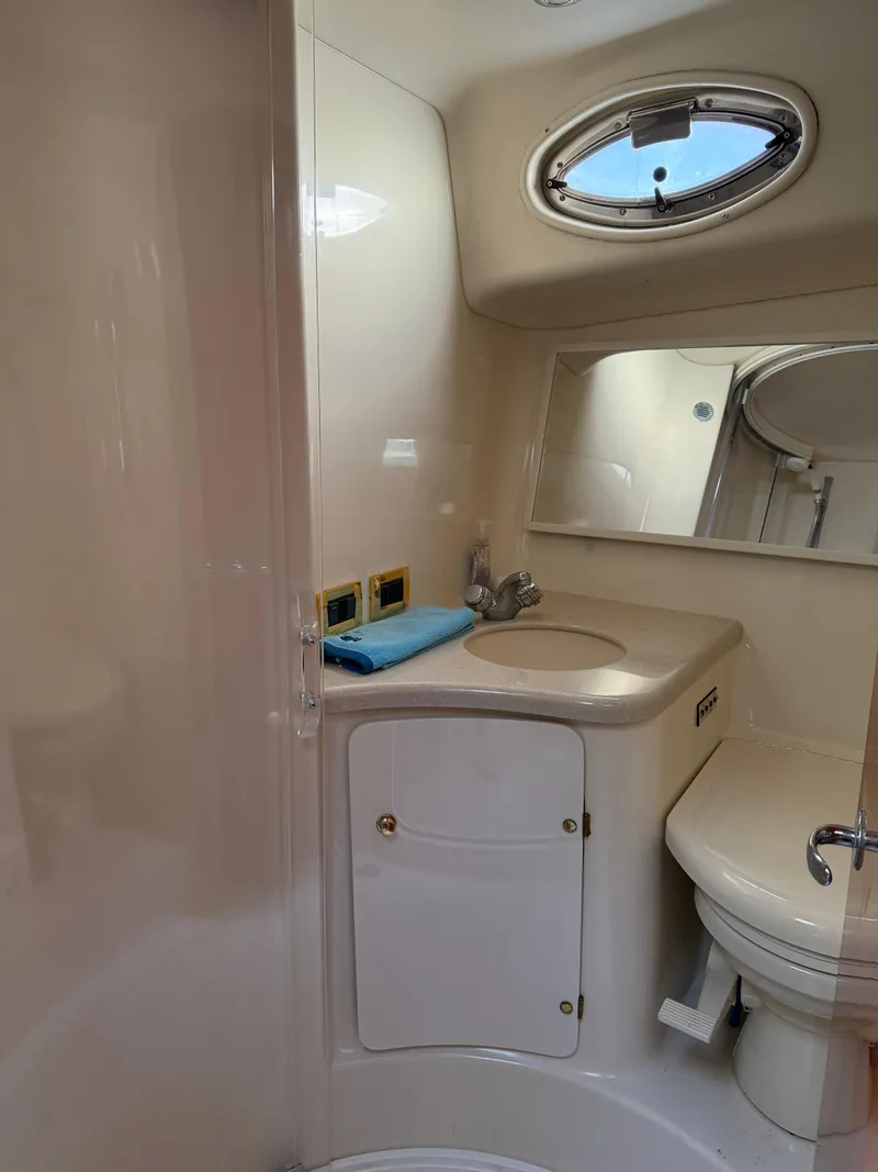 Slide: The Image of Bathroom interior of 2000 Sea Ray 370 Express Cruiser with sink and porthole window. - 18