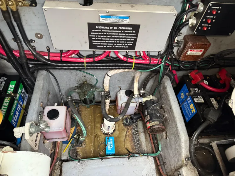 Slide: The Image of Engine compartment of 2000 Sea Ray 370 Express Cruiser with wiring and battery components. - 24