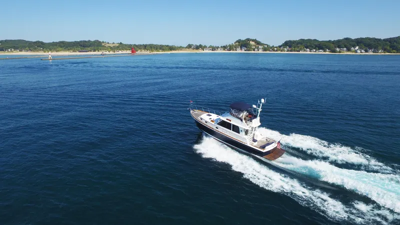 Slide: The Image of 2014 Grand Banks 46 Eastbay FB cruising on open water near a scenic coastline. - 10