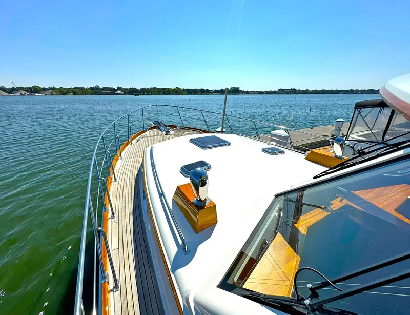 Slide: The Image of 2014 Grand Banks 46 Eastbay FB yacht on calm water, showcasing sleek deck design. - 13