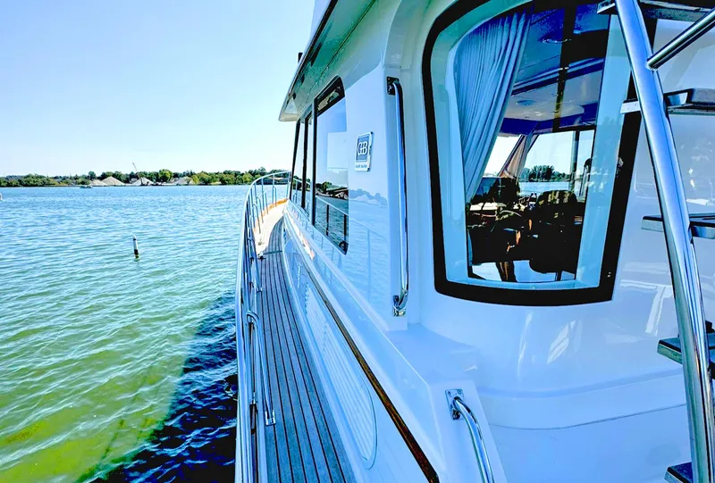 Slide: The Image of 2014 Grand Banks 46 Eastbay FB yacht on calm water, showcasing sleek design and luxury features. - 15