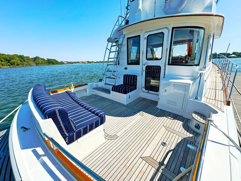 Slide: The Image of Grand Banks 46 Eastbay FB 2014 yacht with striped seating on deck, docked by calm waters. - 20