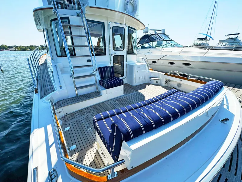 Slide: The Image of 2014 Grand Banks 46 Eastbay FB yacht with striped seating on deck, docked by water. - 21