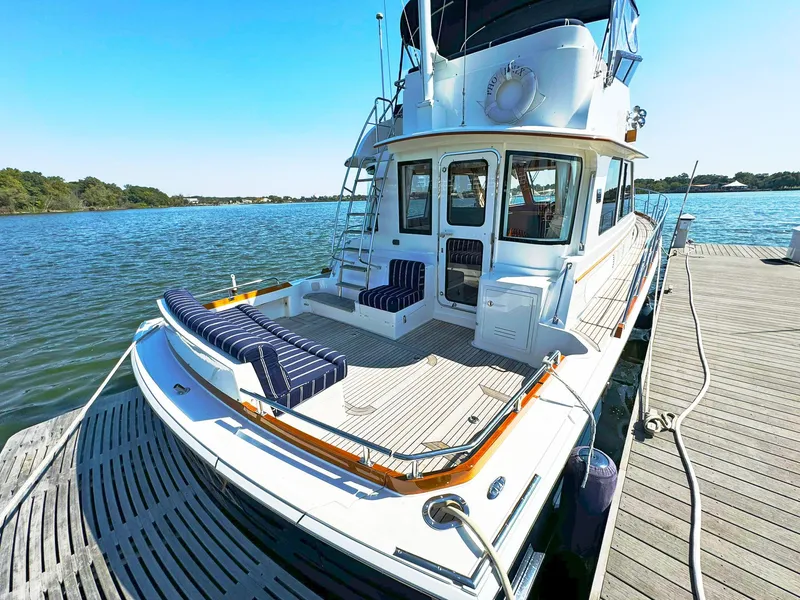 Slide: The Image of 2014 Grand Banks 46 Eastbay FB yacht docked, featuring spacious deck and seating area. - 22
