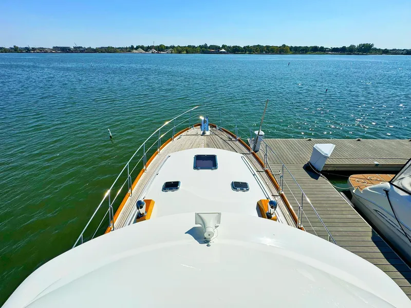 Slide: The Image of 2014 Grand Banks 46 Eastbay FB yacht docked on calm water, sunny day. - 27