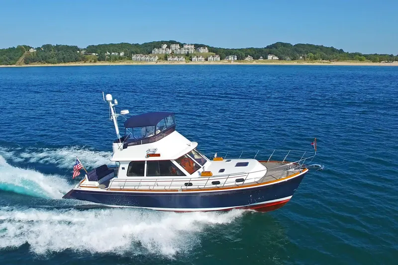 Slide: The Image of 2014 Grand Banks 46 Eastbay FB cruising on blue water near scenic coastline. - 4