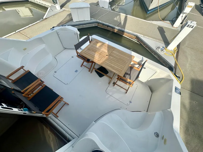 Slide: The Image of 2007 Carver 35 Super Sport yacht deck with wooden table and chairs at marina. - 14