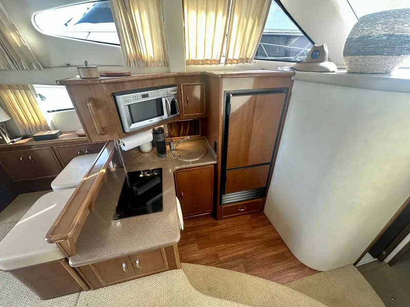 Slide: The Image of 2007 Carver 35 Super Sport yacht interior with kitchenette, featuring microwave and compact fridge. - 26