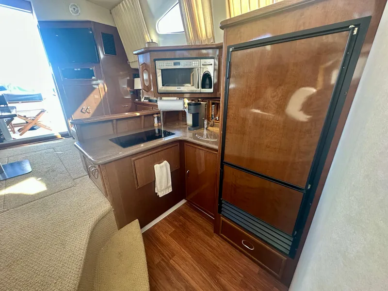 Slide: The Image of 2007 Carver 35 Super Sport yacht kitchen with wood cabinetry and modern appliances. - 29