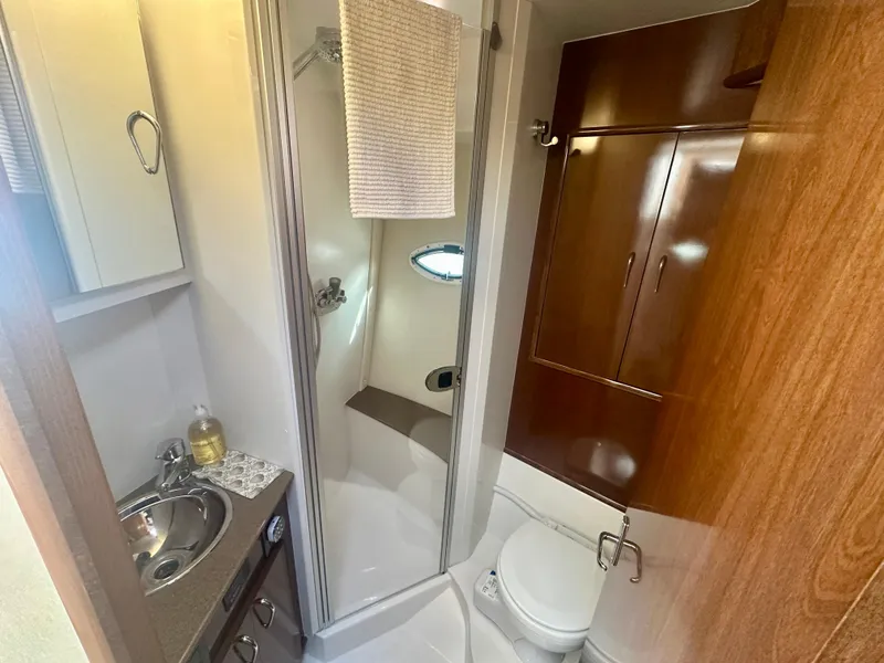 Slide: The Image of 2007 Carver 35 Super Sport yacht bathroom with shower, sink, and wooden cabinetry. - 33