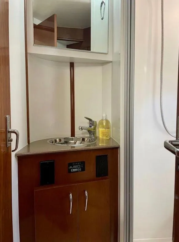Slide: The Image of 2007 Carver 35 Super Sport bathroom with sink, mirror, and wooden cabinetry. - 35