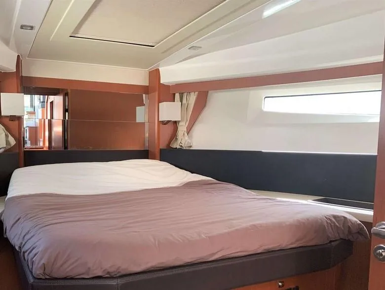 Slide: The Image of Interior cabin of 2017 Jeanneau Velasco 43F yacht with a cozy bed and window. - 18