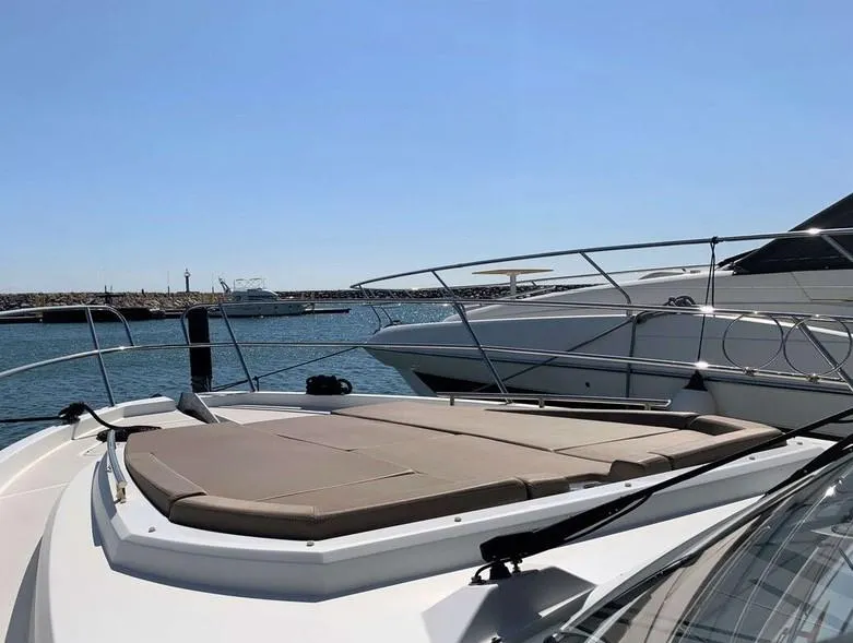 Slide: The Image of 2017 Jeanneau Velasco 43F yacht with sun deck, docked in a marina under clear skies. - 19