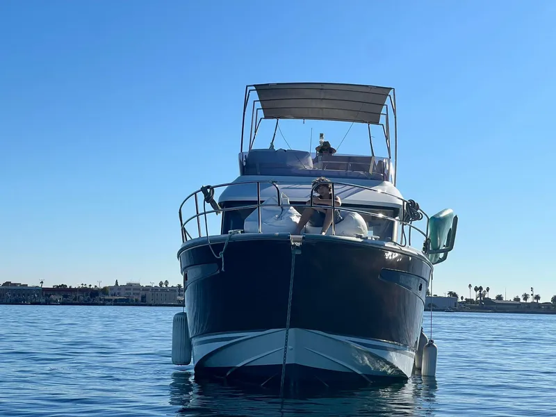 Slide: The Image of 2017 Jeanneau Velasco 43F yacht on calm water under clear blue sky. - 8