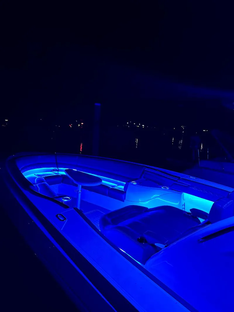 Slide: The Image of 2020 Fountain 39 NX boat with vibrant blue LED lighting at night. - 17