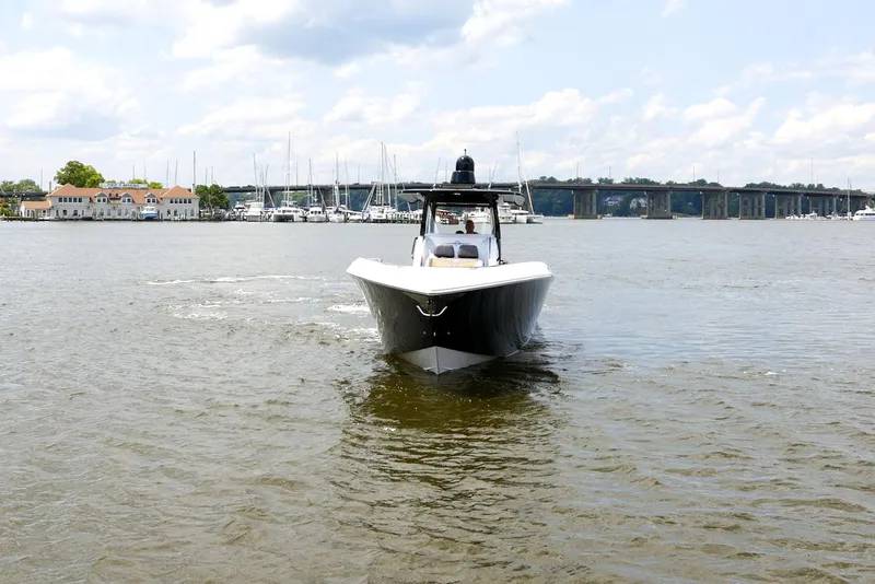 Slide: The Image of 2020 Fountain 39 NX boat cruising on a calm river with a bridge in the background. - 3