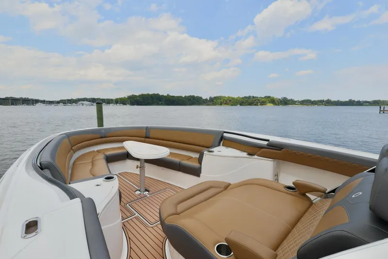 Slide: The Image of 2020 Fountain 39 NX boat interior with tan seating, wooden deck, and scenic water view. - 7